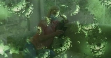 Beyaz kadın üzerinde yüz maskesi takan ve akıllı telefon kullanan virüs hücrelerinin animasyonu. Dijital olarak üretilen küresel covid 19 salgın, ilaç ve sağlık konsepti.