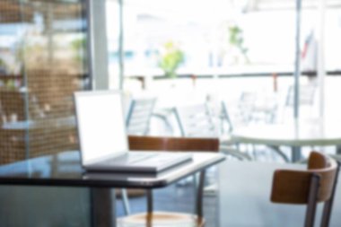 Pencere kenarındaki boş masada dizüstü bilgisayar