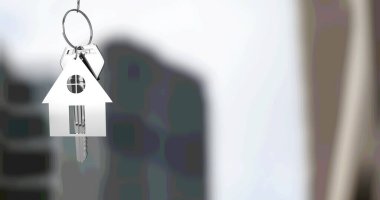 Bulanık şehrin yüksek binasının önünde asılı gümüş ev anahtarlığı ve anahtarı. gayrimenkul işi, ev ve finans kavramı dijital olarak üretilen imaj.