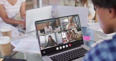 African american man using laptop for video call, with diverse business colleagues on screen. Business communication technology and remote home working, digital composite video.