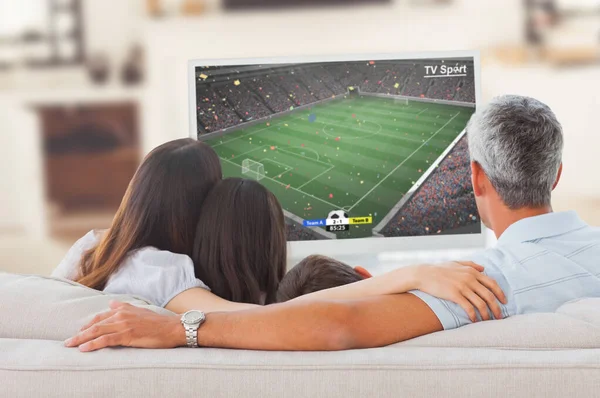 Jogador Futebol Chutando Bola Contra Família Assistindo Televisão Juntos Sofá — Fotografia de Stock