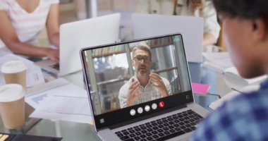 African american man using laptop for video call, with business colleague on screen. Business communication technology and remote home working, digital composite video.