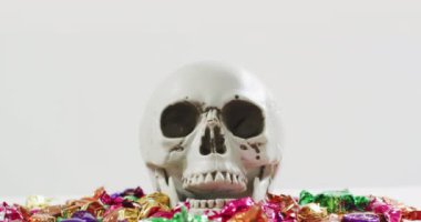 Kafatasında gri arkaplanda şekerlerle cadılar bayramı metni canlandırması. Cadılar Bayramı, sonbahar, sonbahar, bayram geleneği ve dijital olarak üretilen video konsepti.