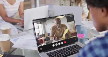 African american man using laptop for video call, with business colleague on screen. Business communication technology and remote home working, digital composite video.