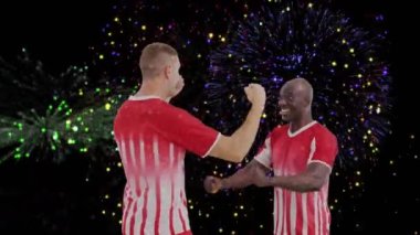 Çeşitli erkek futbol oyuncularının el kaldırması üzerine havai fişek gösterisi. Küresel spor ve dijital arayüz kavramı dijital olarak oluşturulmuş video.