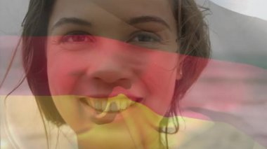 Beyaz kadının plajda gülümseyen portresinin üzerinde Alman bayrağı sallayan birleşik video. Ulusal turizm ve seyahat kavramı