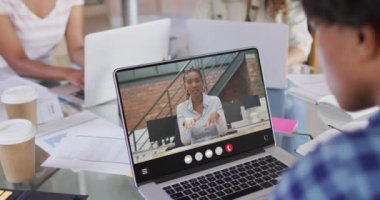 African american man using laptop for video call, with business colleague on screen. Business communication technology and remote home working, digital composite video.