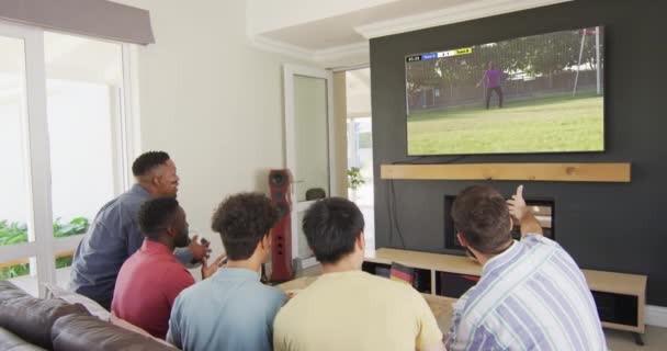 不同朋友坐在沙发上看电视上看足球的视频 竞争和在家里度过家庭时光 — 图库视频影像