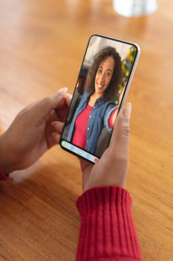 Video ekranında Noel ağacı olan mutlu Afro-Amerikan bir kadınla el ele tutuşmak. Noel, şenlik ve iletişim teknolojisi.