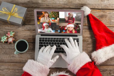 Noel Baba, Kafkasyalı arkadaş grubuyla birlikte dizüstü bilgisayardan video görüşmesi yapıyor. Noel, şenlik ve iletişim teknolojisi.