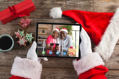 Noel Baba, Afrika kökenli Amerikalı bir çiftle Noel bilgisayarlı video görüşmesi yapıyor. Noel, şenlik ve iletişim teknolojisi.