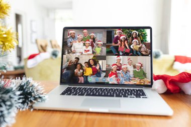 Yılbaşı zamanı dizüstü bilgisayar grubunun ekranında gülümseyen mutlu aileler. Noel, şenlik ve iletişim teknolojisi.