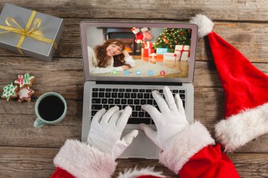 Kafkasyalı bir kadınla Noel Baba 'nın dizüstü bilgisayar görüntüsü. Noel, şenlik ve iletişim teknolojisi.