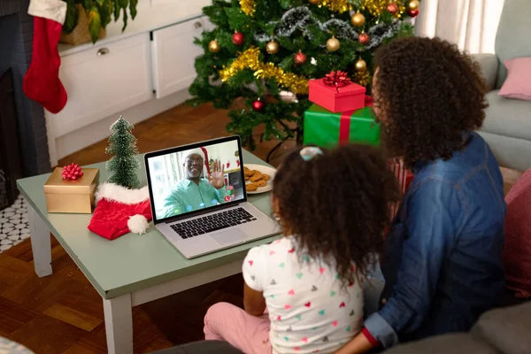 アフリカ系アメリカ人の母親と娘が男性の友人とクリスマスビデオ通話中 クリスマスやお祭りや通信技術は — ストック写真