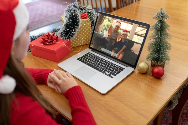 サンタの帽子の白人女性は 白人の父と息子を振ってクリスマスのラップトップビデオ通話を行います クリスマスやお祭りや通信技術は — ストック写真
