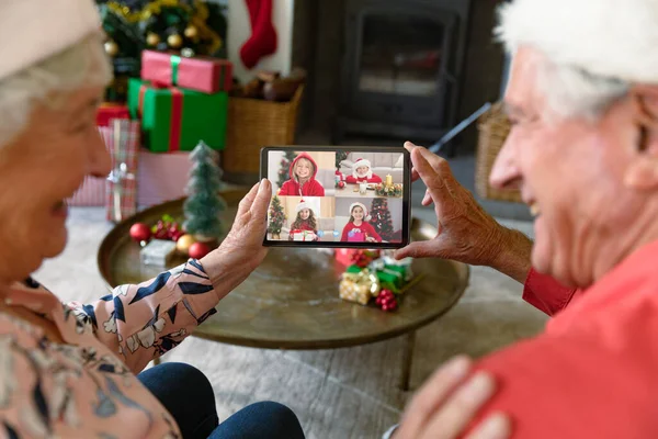 Счастливая Старшая Белая Пара Делает Скрипичный Рождественский Видеозвонок Четырьмя Улыбающимися — стоковое фото