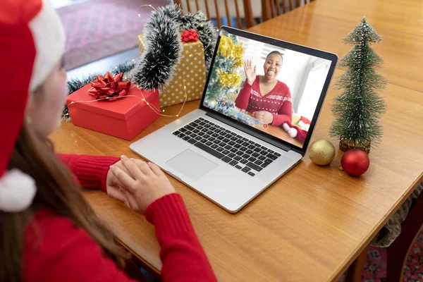 戴着圣诞礼帽的白人女人和笑着的非洲裔美国女人一起做圣诞手提电脑视频通话 圣诞节 节日和通信技术 — 图库照片