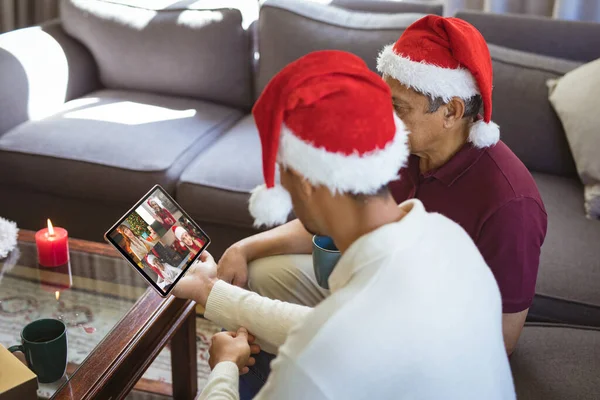 Biracial Apa Felnőtt Fia Télapó Sapkában Hogy Tabletta Karácsonyi Csoport — Stock Fotó