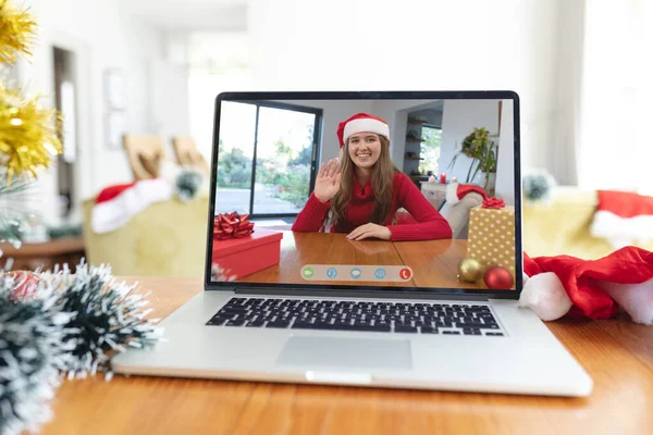 圣诞期间 戴着圣诞礼帽的快乐的高加索女人在手提电脑视频呼叫屏幕上挥手 圣诞节 节日和通信技术 — 图库照片