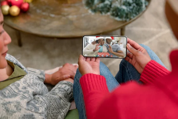 在智能手机的圣诞视频电话里 与一对年长的夫妇有一个非常要好的女友 圣诞节 节日和通信技术 — 图库照片
