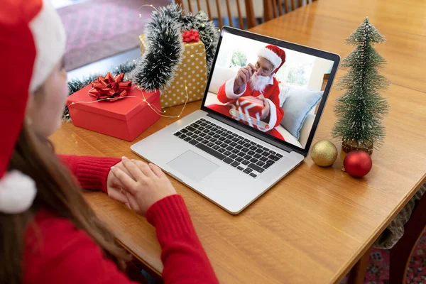 サンタの帽子の白人女性は ラップトップのクリスマスビデオ通話をサンタの衣装のシニア男性と作ります クリスマスやお祭りや通信技術は — ストック写真