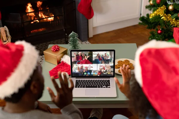 戴着圣诞礼帽的非洲裔美国人夫妇和他们的朋友们一起在电脑上通过视频通话 圣诞节 节日和通信技术 — 图库照片