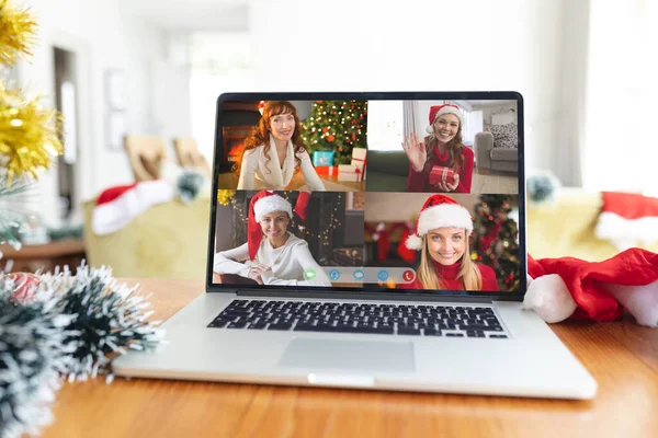 在笔记本电脑的圣诞团体视频呼叫界面屏幕上 四个戴着圣诞礼帽 面带微笑的高加索女人 圣诞节 节日和通信技术 — 图库照片