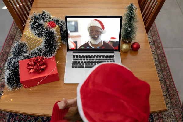 ラップトップのクリスマスのビデオ通話でサンタの帽子の白人女性は笑顔のシニア男性と呼びます クリスマスやお祭りや通信技術は — ストック写真