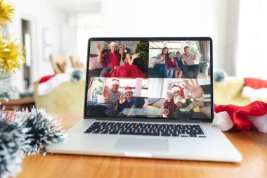 Yılbaşı Noel Baba şapkalı mutlu arkadaşlar ve aileler dizüstü bilgisayar grubu arayüz ekranında. Noel, şenlik ve iletişim teknolojisi.