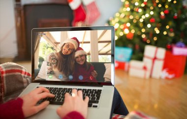 Arkadan görünüş üstünde laptop Noel'de evde oturma odasında yazarak redhead