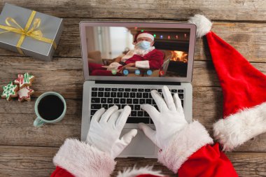Noel Baba 'nın, Kafkasyalı Noel Baba' nın yüz maskesi taktığı dizüstü bilgisayar görüntülü araması. Noel, şenlik ve iletişim teknolojisi.