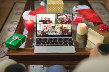 Mutlu Kafkasyalı aile üyeleri Noel zamanı dizüstü bilgisayar grubu görüntülerine el sallıyor. Noel, şenlik ve iletişim teknolojisi.