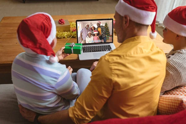 白种人的父亲和戴着圣诞礼帽的儿子们用快乐多样的家庭拨打了圣诞手提电脑视频电话 圣诞节 节日和通信技术 — 图库照片