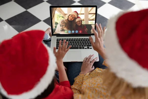 友達とクリスマスノートパソコンのビデオ通話でサンタの帽子の白人の母親と娘 クリスマスやお祭りや通信技術は — ストック写真