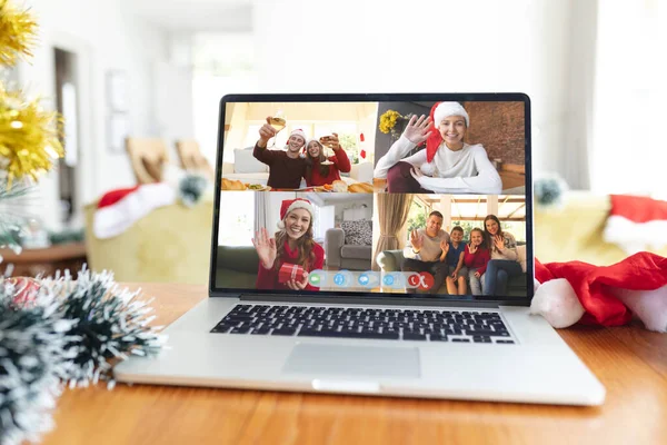 Mutlu Kafkasyalı aile üyeleri Noel 'de dizüstü bilgisayarda video ekranında el sallıyor ve kadeh kaldırıyor. Noel, şenlik ve iletişim teknolojisi.
