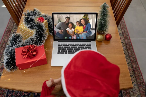 笑顔のアフリカ系アメリカ人の家族とラップトップのクリスマスビデオ通話を作る白人女性 クリスマスやお祭りや通信技術は — ストック写真