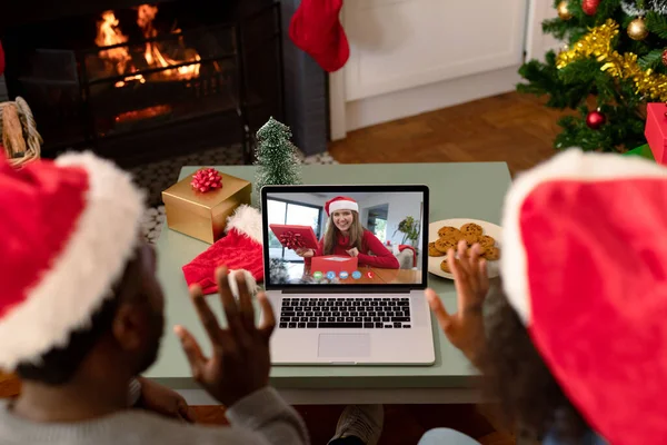 クリスマスのビデオ通話でサンタの帽子のアフリカ系アメリカ人のカップルは女性の友人と クリスマスやお祭りや通信技術は — ストック写真
