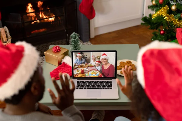 家族と一緒にクリスマスのビデオ通話でサンタの帽子のアフリカ系アメリカ人のカップル クリスマスやお祭りや通信技術は — ストック写真