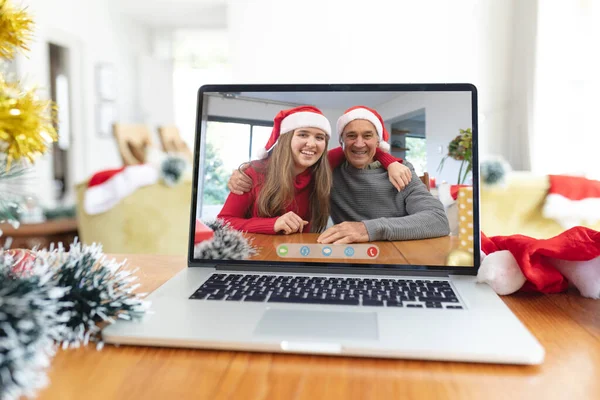 圣诞节时 戴着桑塔帽的白人父亲和成年女儿在笔记本电脑视频呼叫屏幕上笑着 圣诞节 节日和通信技术 — 图库照片