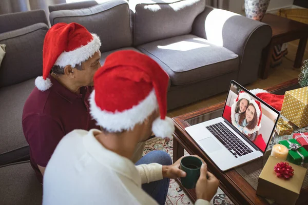 幼い父親と大人の息子は 笑顔の母親と娘とラップトップのクリスマスビデオ通話を作ります クリスマスやお祭りや通信技術は — ストック写真