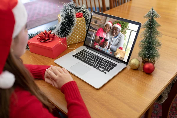 戴着圣诞礼帽的白人女人带着笑着的非洲裔美国夫妇打来圣诞手提电脑视频电话 圣诞节 节日和通信技术 — 图库照片