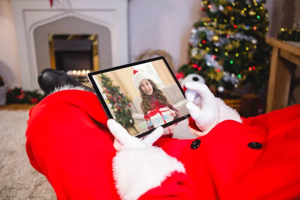 サンタクロースはサンタの帽子で幸せな白人の女の子とクリスマスのラップトップビデオ通話を作る クリスマスやお祭りや通信技術は — ストック写真