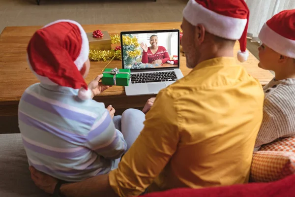 白种人的父亲和戴着桑塔帽的儿子们和挥手的女性朋友一起制作了圣诞笔记本视频 圣诞节 节日和通信技术 — 图库照片