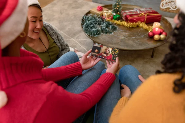 圣诞视频中 一群戴着圣诞礼帽的不同女性朋友与朋友在智能手机上通话 圣诞节 节日和通信技术 — 图库照片