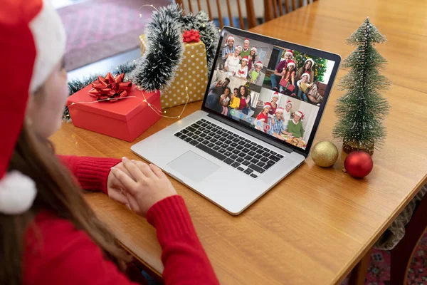 戴着圣诞礼帽的白人妇女与不同的朋友和家人一起制作圣诞手提电脑视频通话 圣诞节 节日和通信技术 — 图库照片