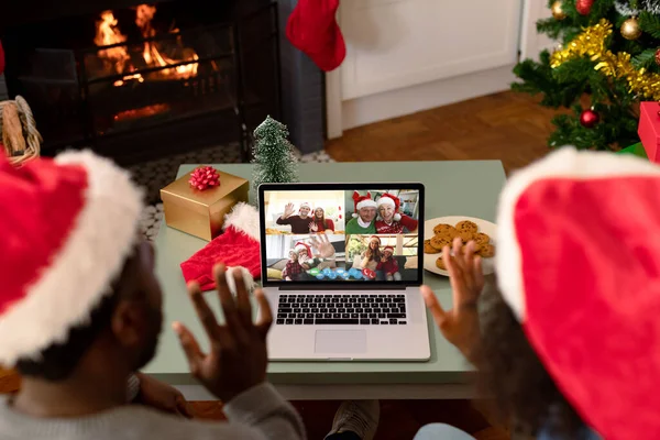 友人とラップトップのクリスマスビデオ通話でサンタの帽子のアフリカ系アメリカ人のカップル クリスマスやお祭りや通信技術は — ストック写真