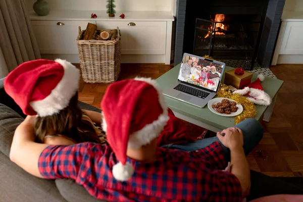 クリスマスのノートパソコンのビデオ通話でサンタの帽子の白人カップル友人と クリスマスやお祭りや通信技術は — ストック写真