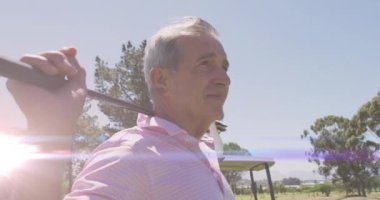 Golf sahasında golf oynayan yaşlı, beyaz bir adamın üzerindeki ışık izlerinin animasyonu. global sporlar, golf ve sağlıklı yaşam tarzı konsepti dijital olarak oluşturulmuş video.