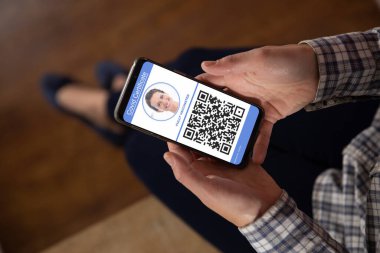 Elinde kovanlı 19 aşılı pasaportlu akıllı telefon tutan bir kadın. küresel covid 19 salgın konsepti dijital olarak oluşturulmuş video.