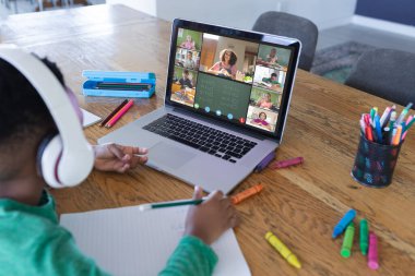 Ekranda farklı ilkokul öğrencileri olan Afro-Amerikan çocuk, video görüşmesi için dizüstü bilgisayar kullanıyor. iletişim teknolojisi ve çevrimiçi eğitim, dijital kompozit resim.